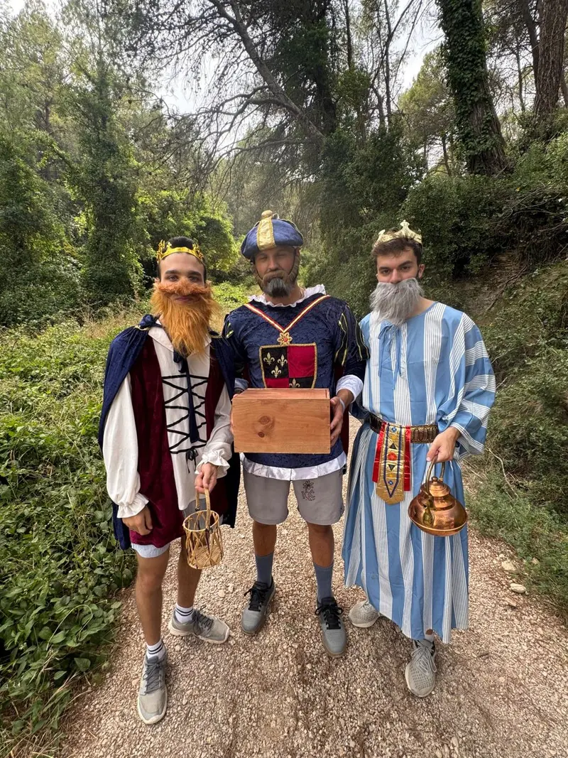 Tres monitores disfrazados de Reyes Magos en un camino del bosque